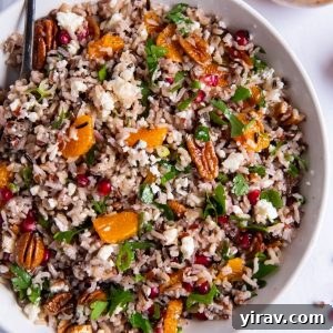 Wild rice salad in a white bowl with a serving spoon