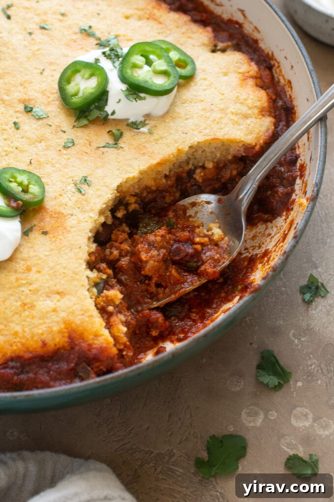 Comforting Chili Cornbread Bake 3 Close-up of Chili Casserole with Cornbread Topping in a cast iron skillet, ready to be served.