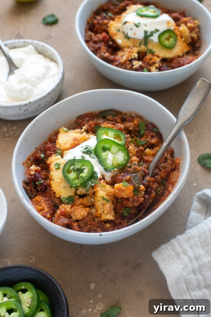 Comforting Chili Cornbread Bake 9 A close-up shot of a bowl of easy cornbread chili casserole, topped with sour cream, sliced jalapeños, and fresh cilantro, inviting you to dig in.