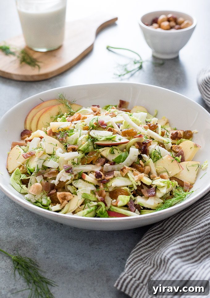 A close-up shot of the finished Creamy Brussels Sprout Slaw with all ingredients mixed in a bowl, showcasing its vibrant texture.