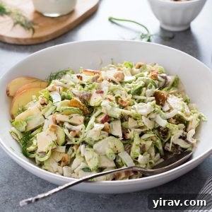 Shaved brussels sprout salad in a bowl with serving spoon