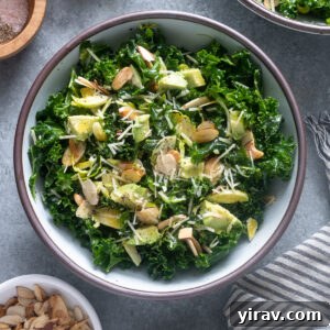 Kale salad with shaved brussels sprouts and avocado in a bowl, ready to serve.