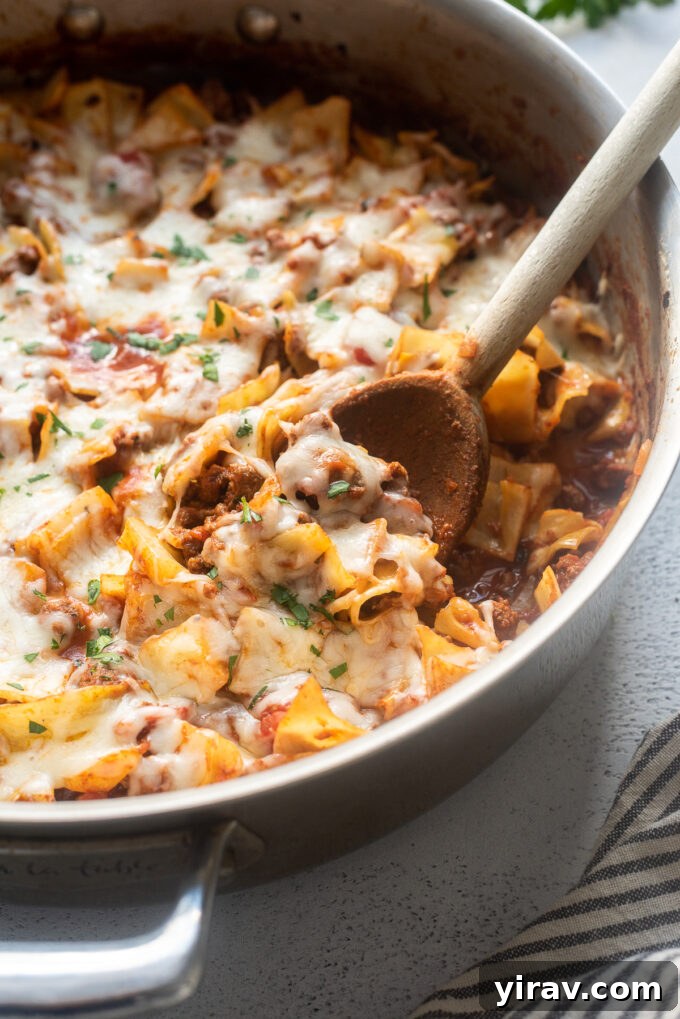 Hearty Beef and Cabbage Bake 6 Low carb cabbage roll casserole in a cast iron skillet with a wooden spoon, showcasing its rustic and comforting appeal.