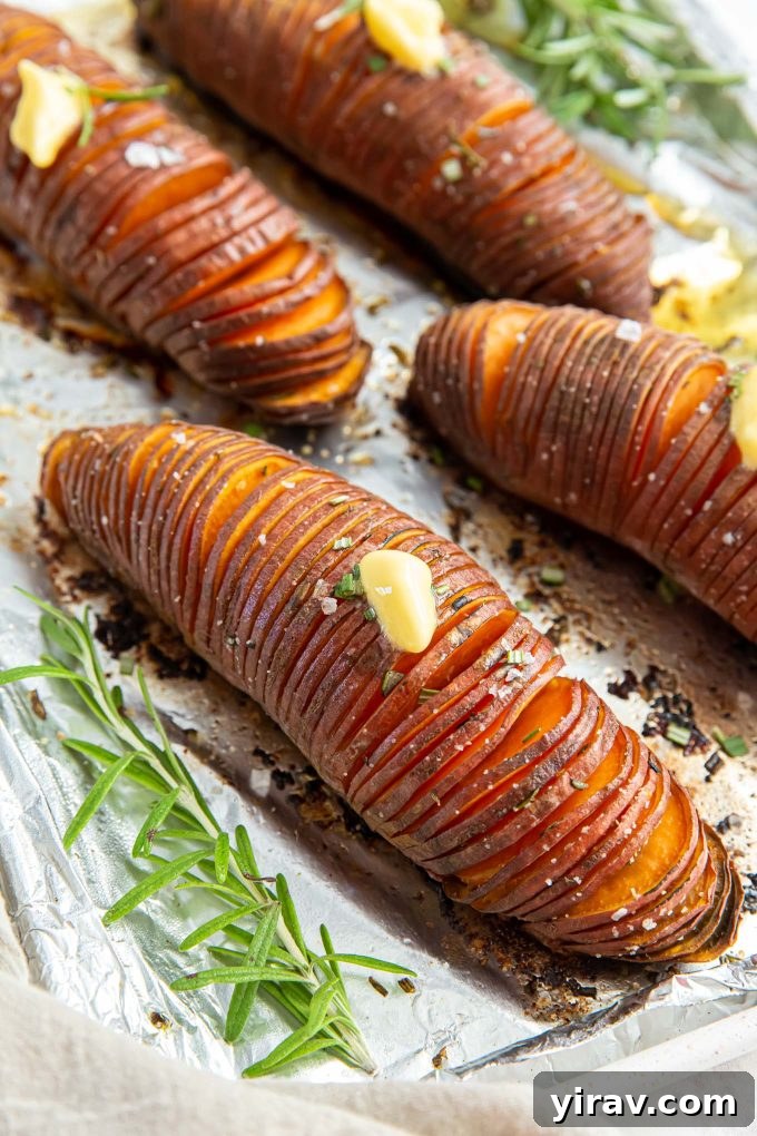 Crispy Hasselback Sweet Potatoes 6 Hasselback sweet potatoes arranged on a baking sheet, ready for the oven