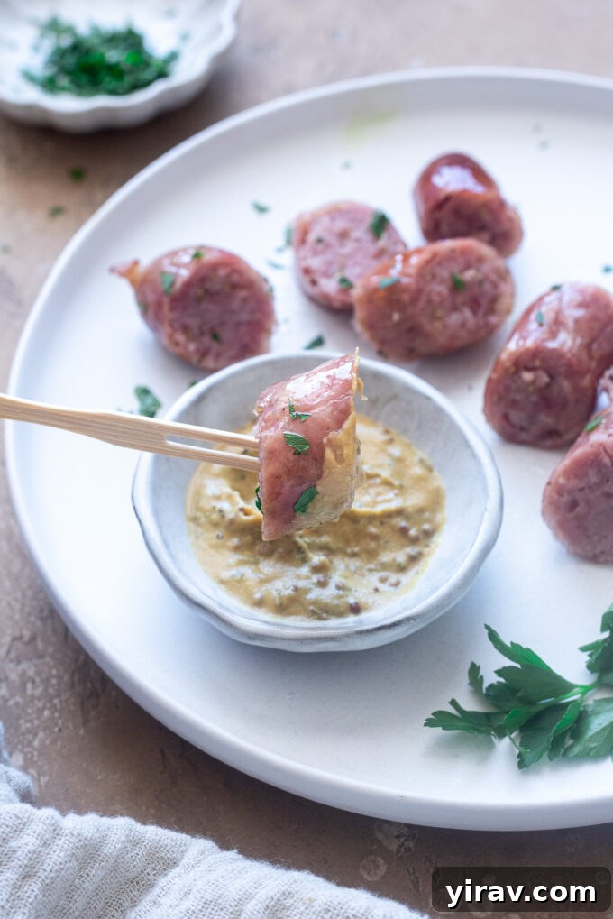 Air fryer Italian sausage sliced on a plate with mustard.