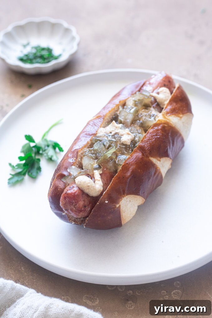 Air fryer sausage links in pretzel buns with toppings.