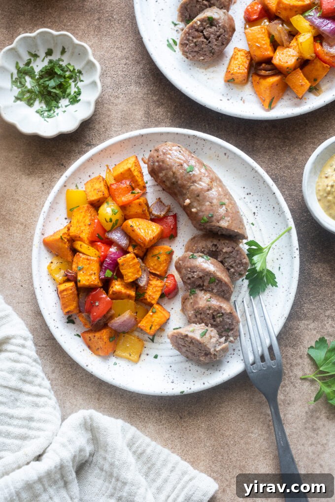 Sheet pan sausage, peppers and sweet potatoes on a plate.