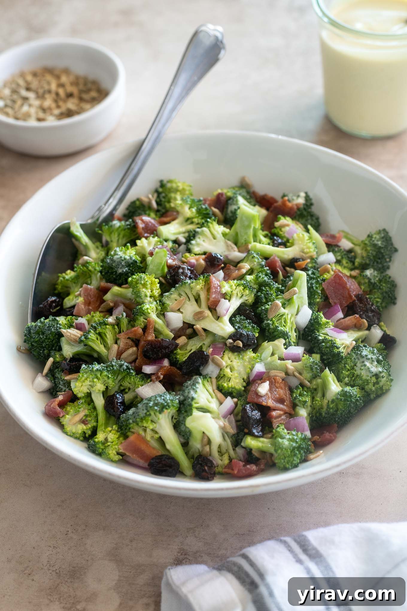 Broccoli salad with bacon in a bowl with serving spoon