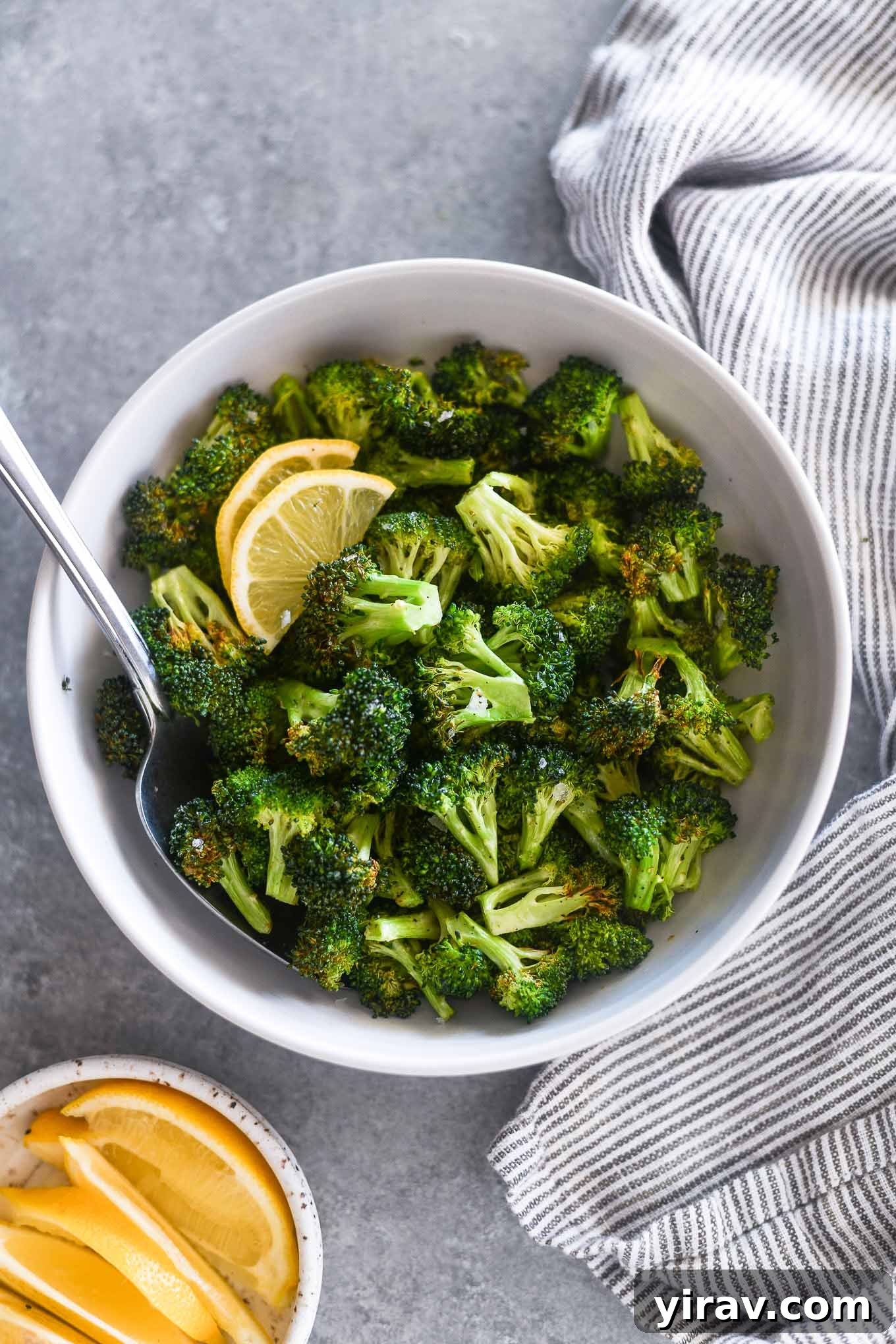 Serving spoon buried in a bowl of air fryer broccoli