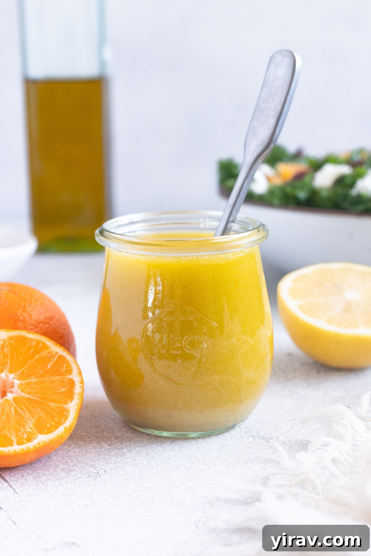 Citrus vinaigrette in a jar with spoon inside.