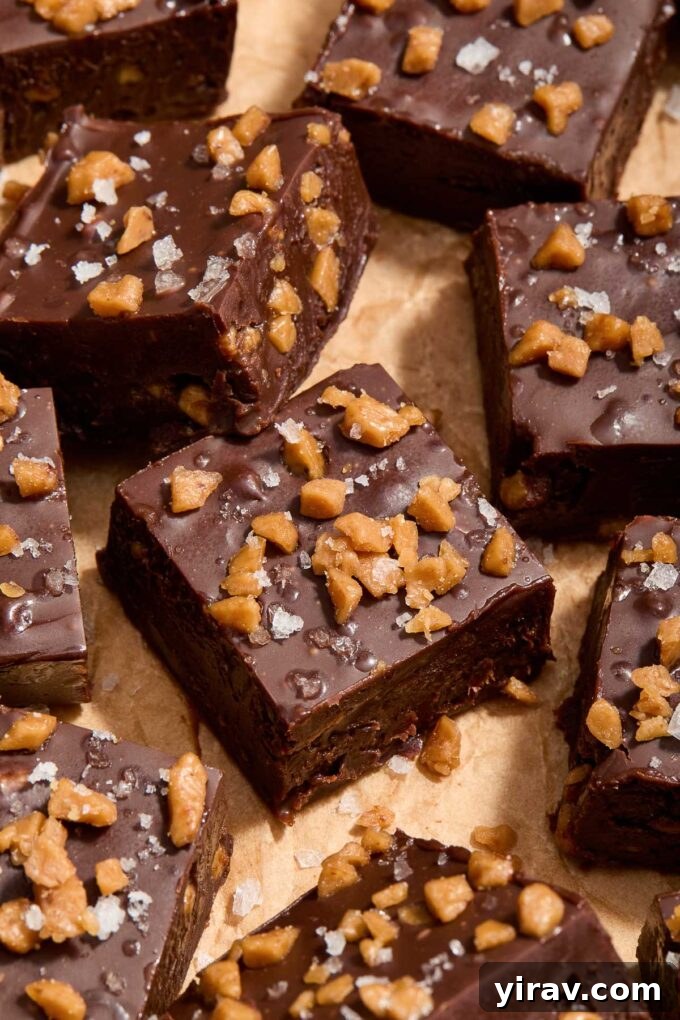 Dark chocolate toffee fudge cut into squares on parchment paper, ready to be served.