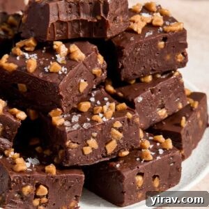 Squares of dark chocolate fudge piled on a plate.