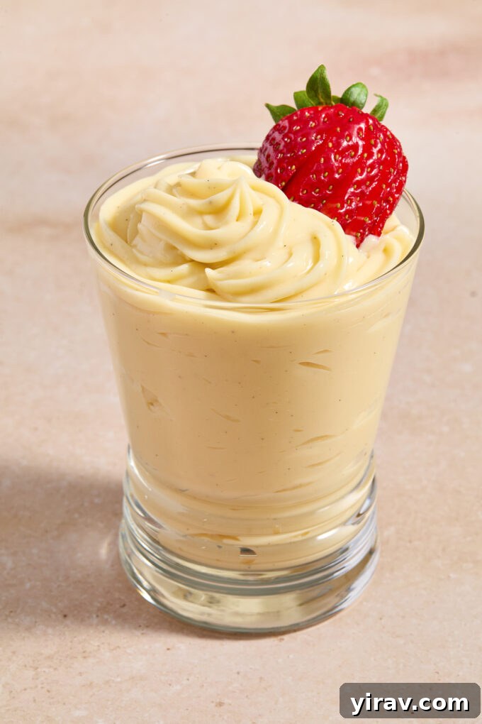Pastry cream piped into a glass with strawberry on top.