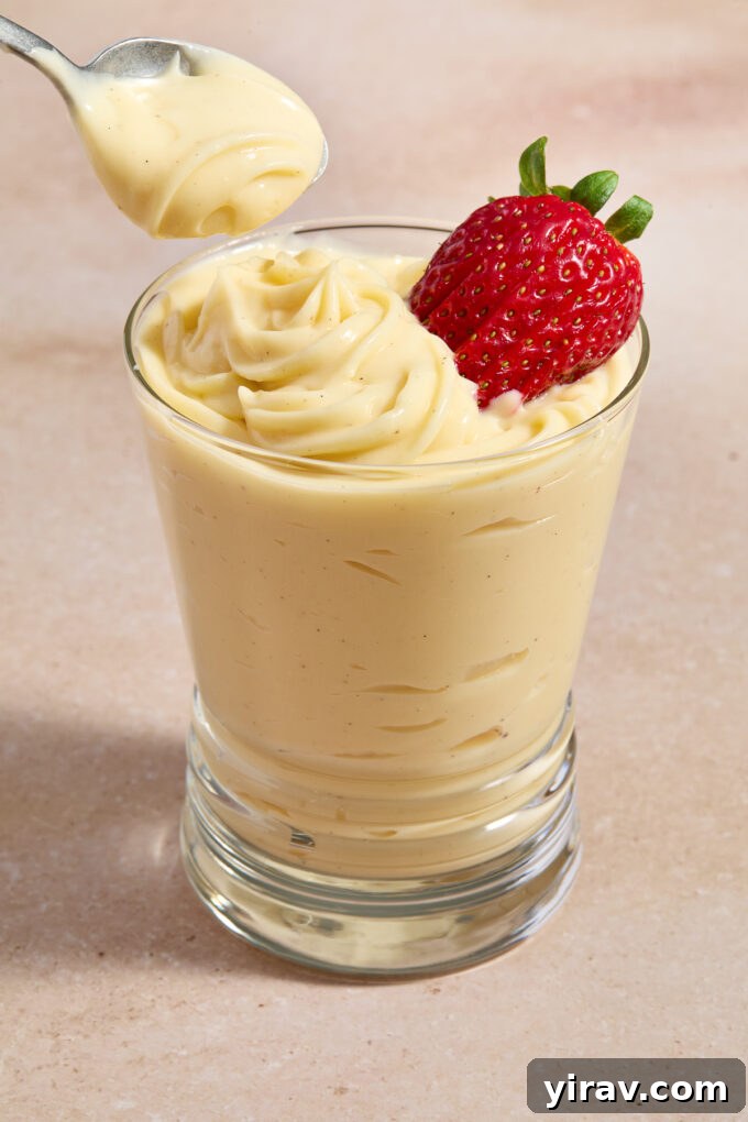 Creme patissiere piped into glass with strawberry on top.