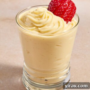 Pastry cream piped into a glass with strawberry on top.