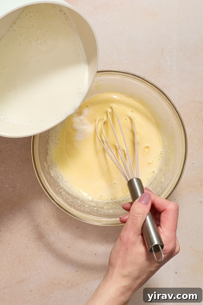 Milk pouring slowly into pastry cream.
