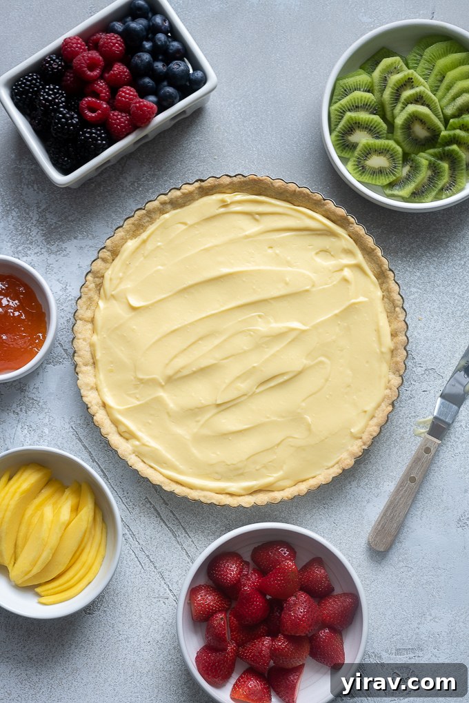 Cooled tart crust being filled with smooth vanilla pastry cream