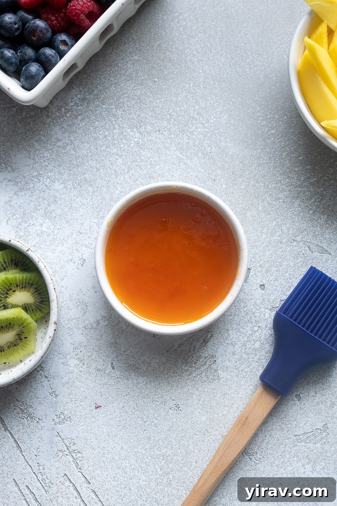 Small ramekin containing warm, melted apricot jelly for glazing the tart