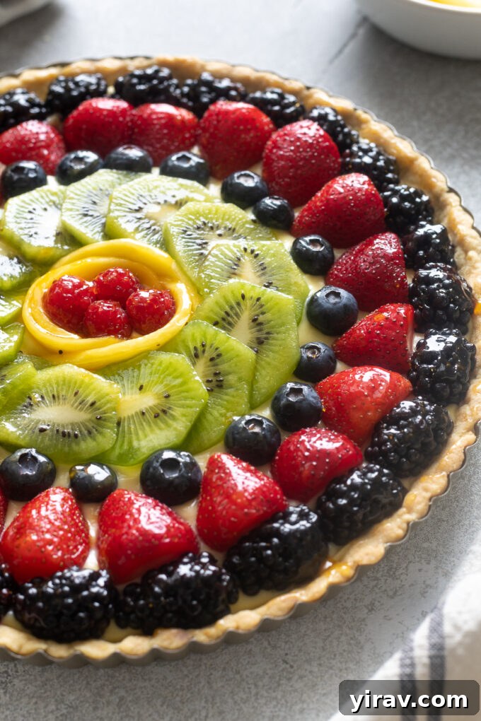 A vibrant fresh fruit tart showcasing an assortment of berries, kiwi, and mango slices