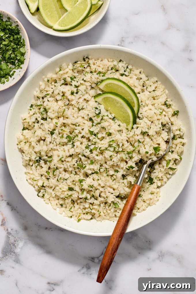 Cilantro lime cauliflower rice in a bowl with serving spoon.