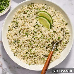 Cilantro lime cauliflower rice in a bowl with serving spoon.