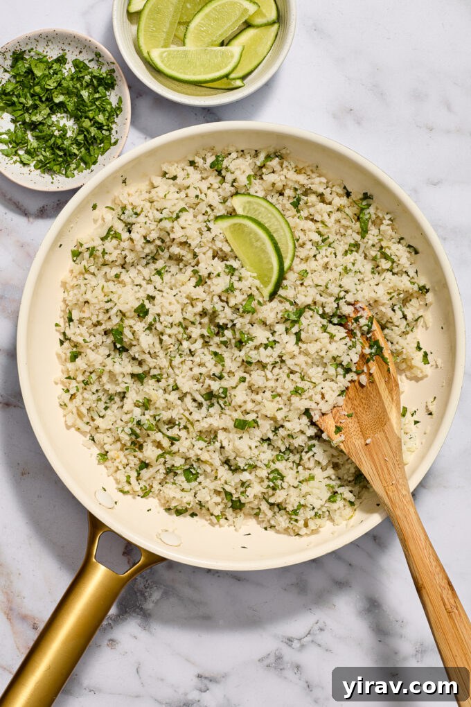 Cilantro Lime Riced Cauliflower in a skillet with wooden spoon.