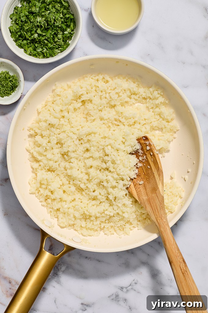 Cooked frozen riced cauliflower in skillet.