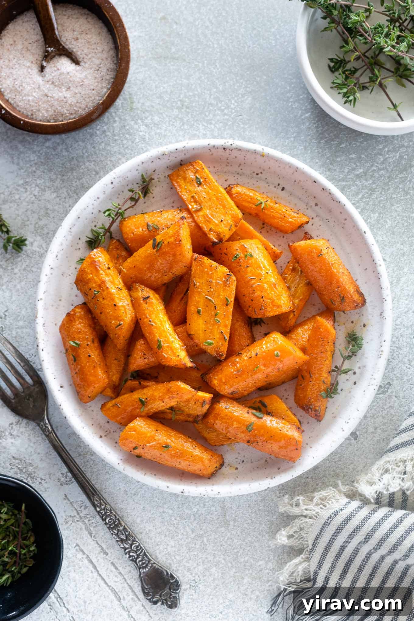 Perfectly air-fried carrots arranged on a plate, garnished with fresh thyme leaves, highlighting their caramelized goodness.