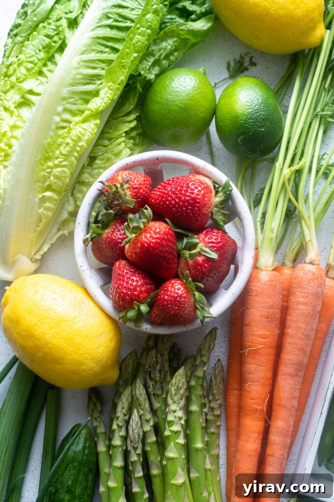 A vibrant collection of May seasonal produce, including bright red strawberries, crisp green lettuce, fresh lemons, and tender asparagus spears, arranged for a delightful spring meal.