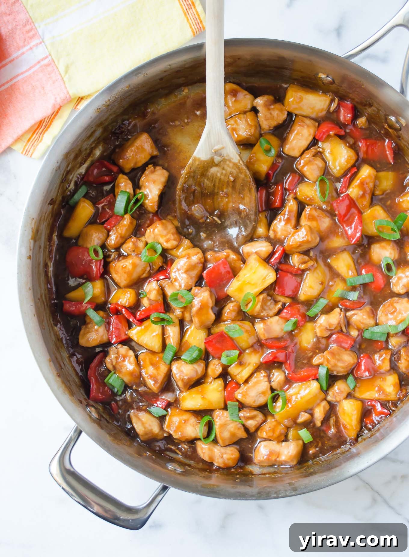 A pan of delicious Honey Pineapple Chicken Teriyaki, served with a wooden spoon, ready to be enjoyed.
