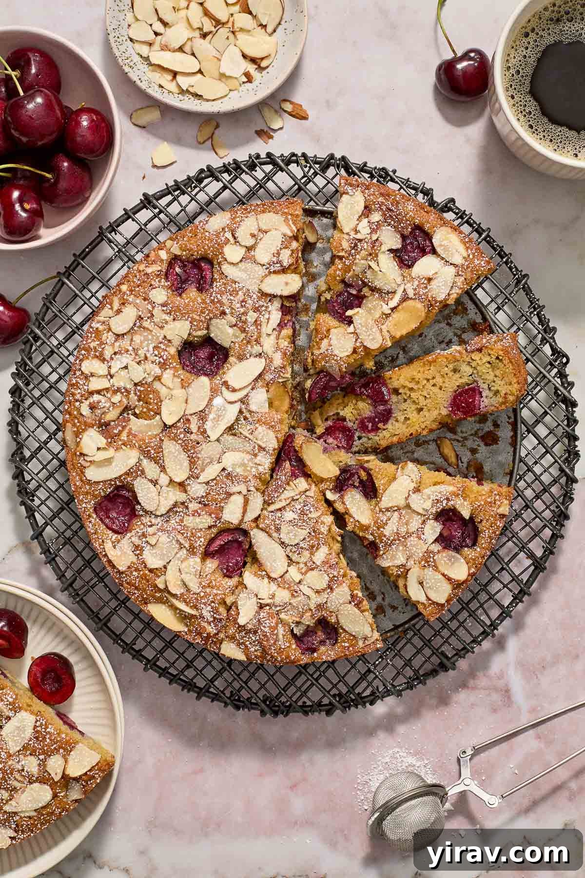 A delicious Cherry Almond Cake, sliced and arranged on a wire rack, showcasing its moist texture.