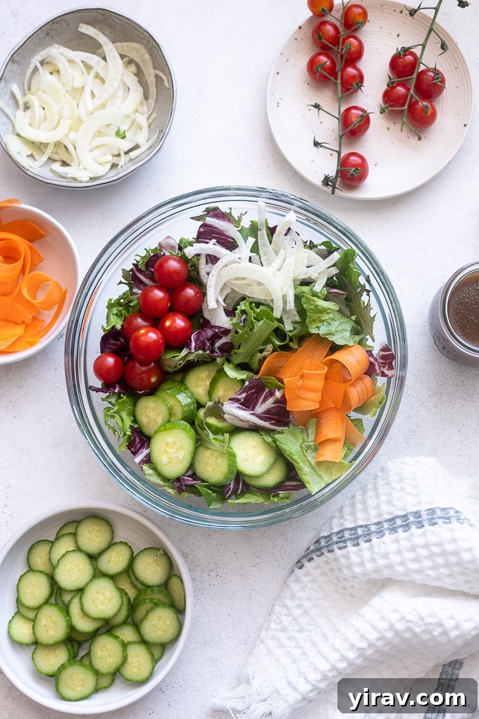 A large mixing bowl filled with all the prepared Insalata Mista ingredients before dressing, showing the colorful mix of greens, vegetables, and fennel.