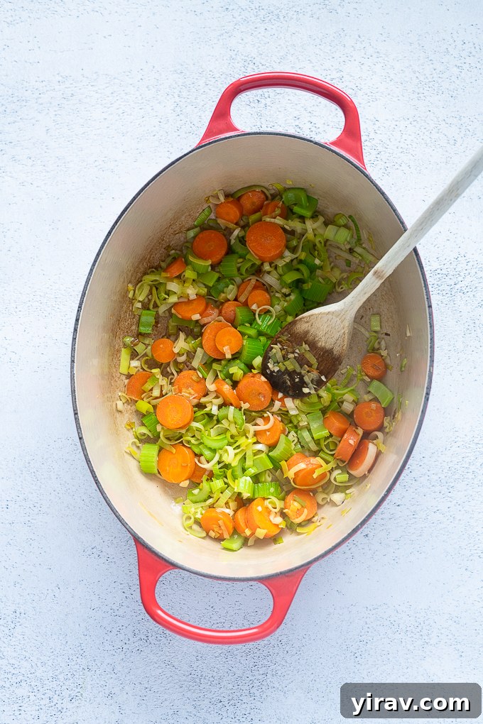 Fresh Spring Harvest Soup 5 Sautéed carrots, celery, and leeks in a pot for spring vegetable soup.
