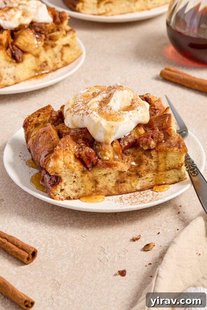 A slice of eggnog french toast on a plate, garnished with whipped cream and a dusting of powdered sugar.