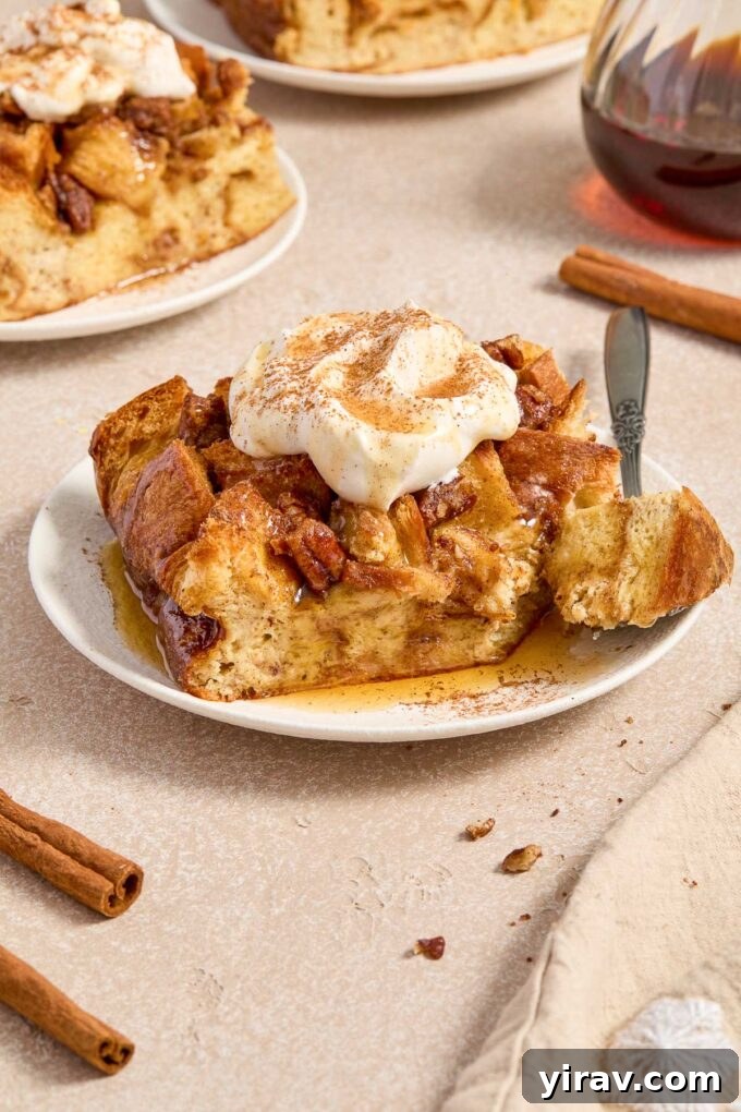 A close-up of a serving of eggnog french toast on a plate, with a fork cutting into the soft, custardy interior.