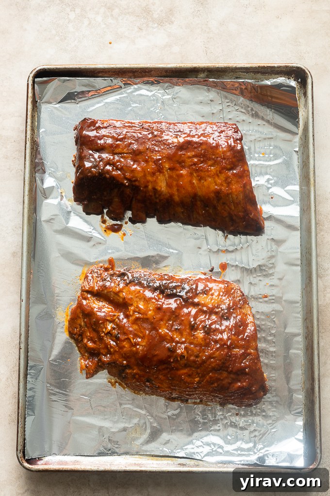 Cooked ribs with additional bbq sauce before broiling.