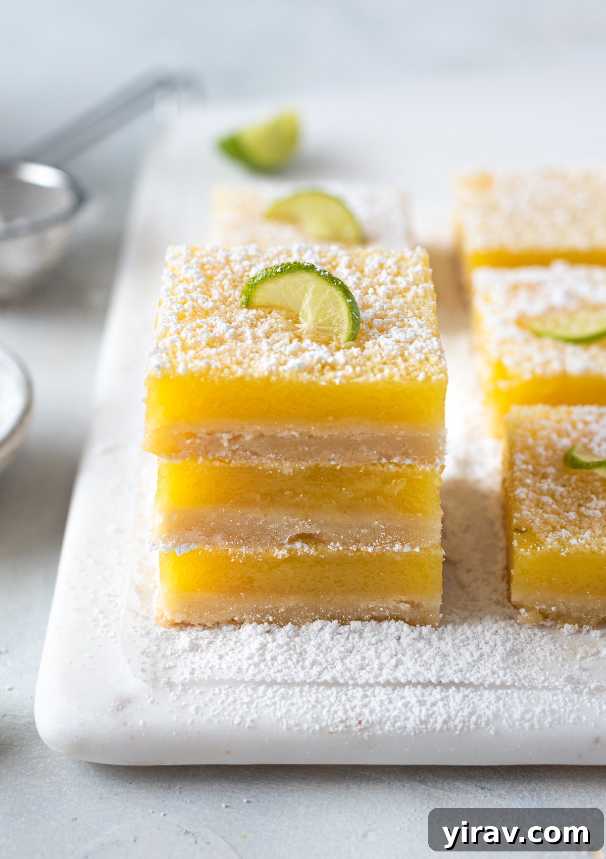 Key lime shortbread bars stacked on top of each other.