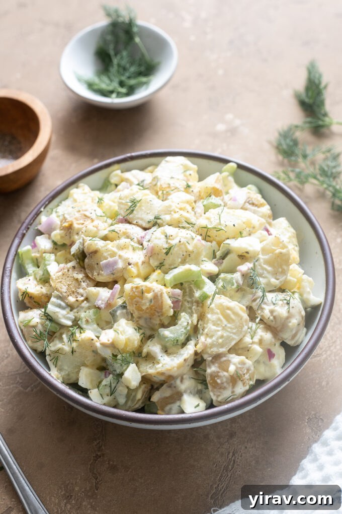 Potato salad with dill and pickles in a serving bowl.