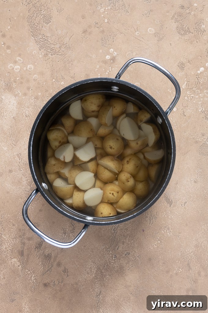 Chopped baby gold potatoes in pot of water.