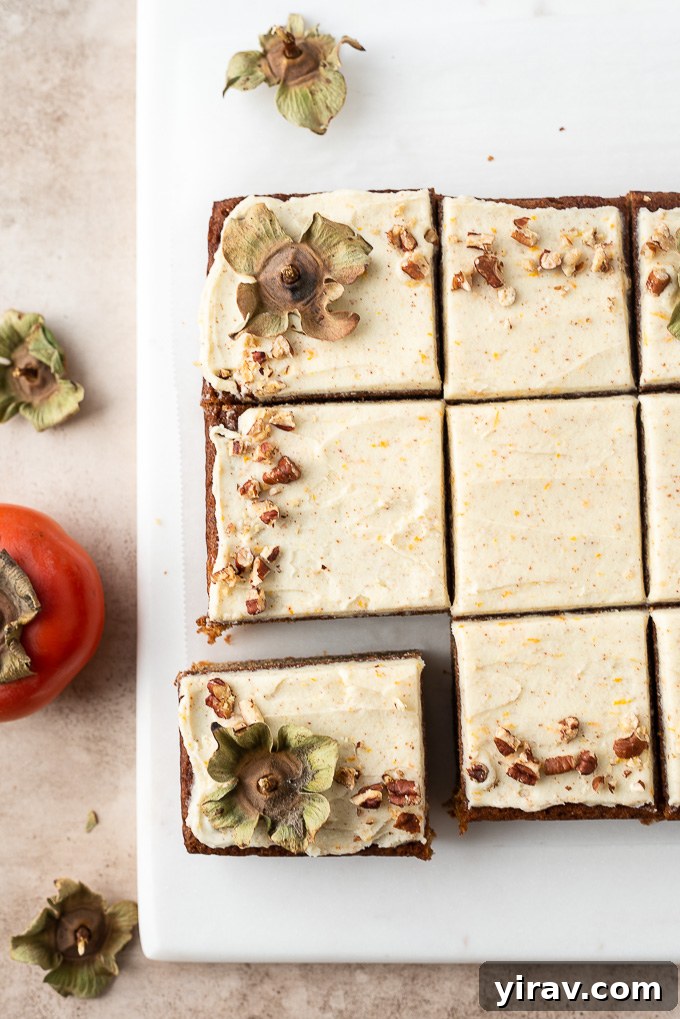 A beautifully sliced persimmon cake revealing its moist interior, topped with brown butter orange frosting.