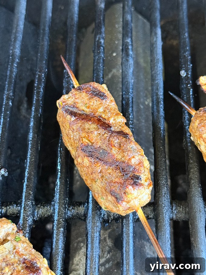 Grilled lamb kofta cooking over indirect heat on the grill.
