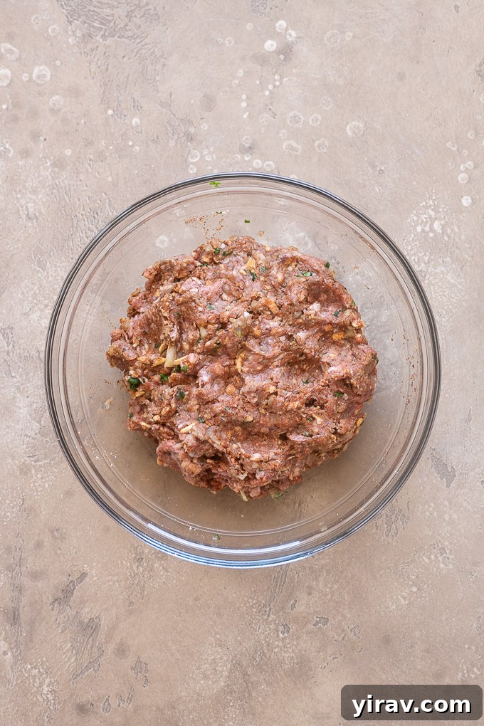 Mixing bowl with ground lamb, herbs, breadcrumbs, and spices for kofta.