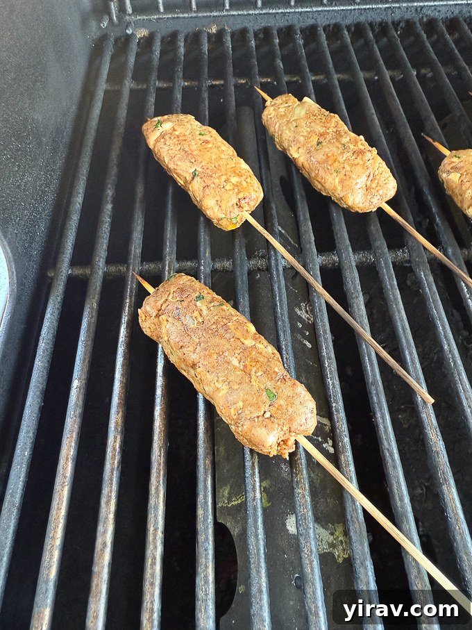 Lamb kofta kebabs searing on a hot grill with visible grill marks.