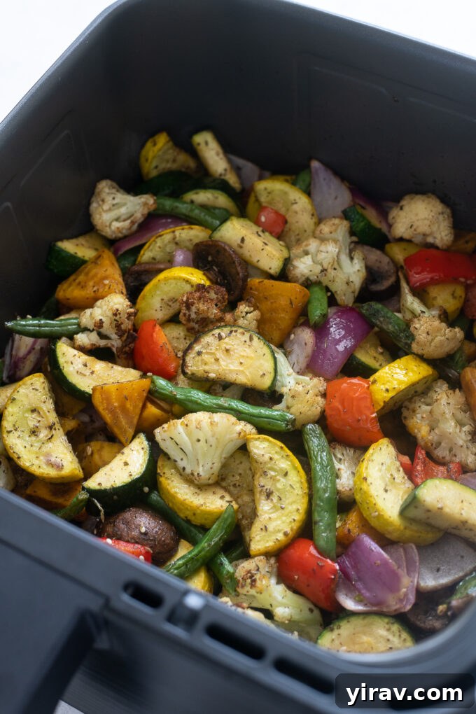 Close-up of golden-brown air fryer roasted vegetables on a serving plate.