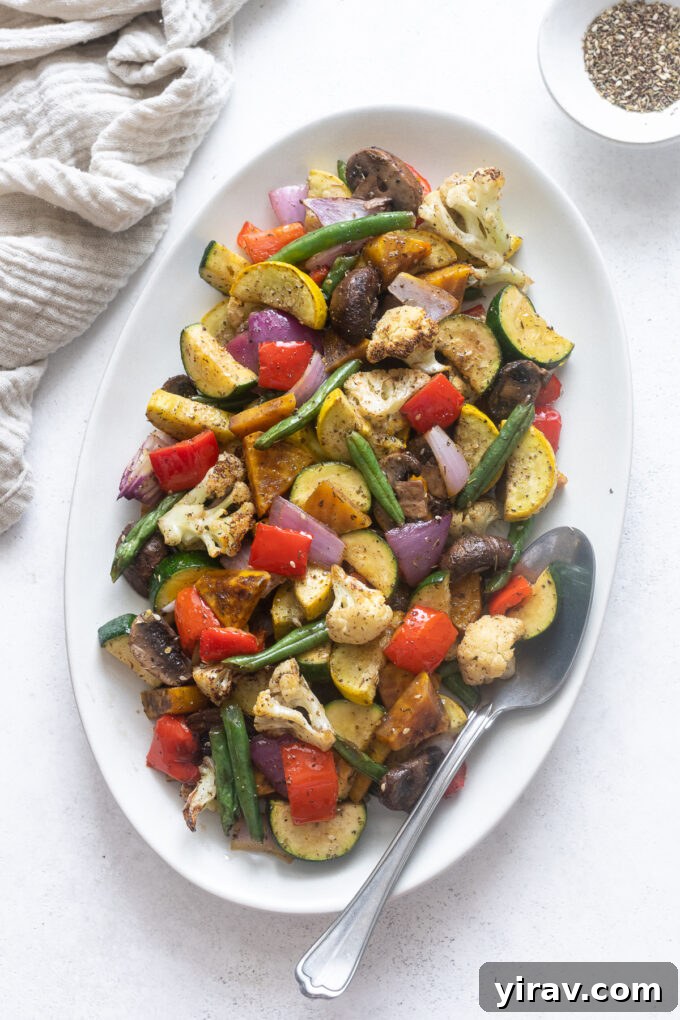 Air fryer roasted vegetables served on a platter with a serving spoon, ready to be enjoyed.