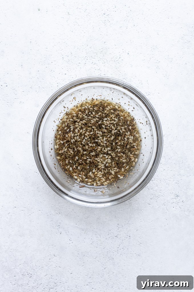 Za'atar seasoning mixed with olive oil in a small bowl, ready for vegetable coating.