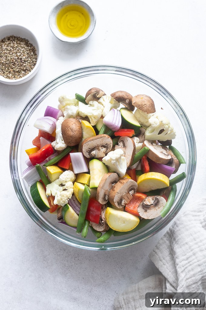 Prepped, cut vegetables in a large mixing bowl, ready for seasoning.