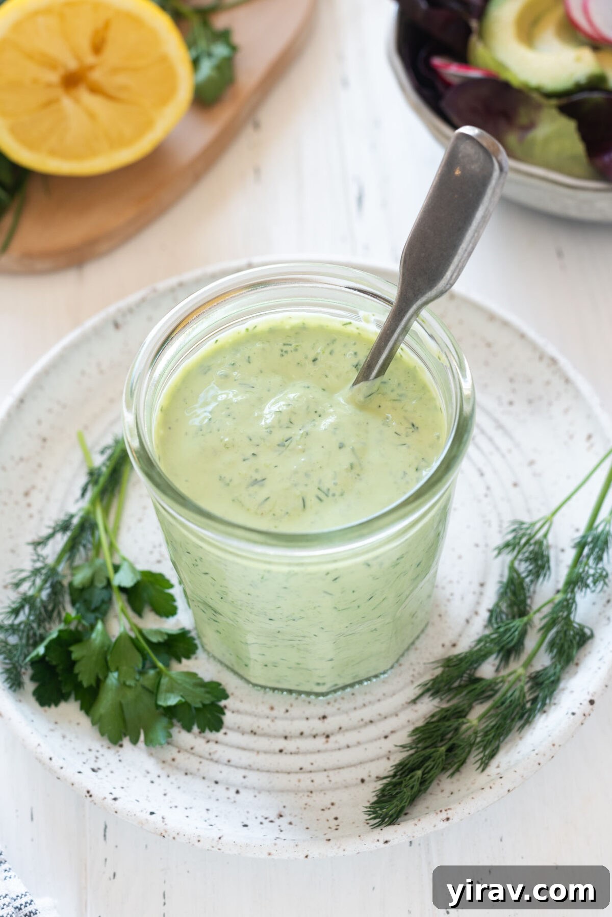 Green goddess dressing in a jar with a spoon