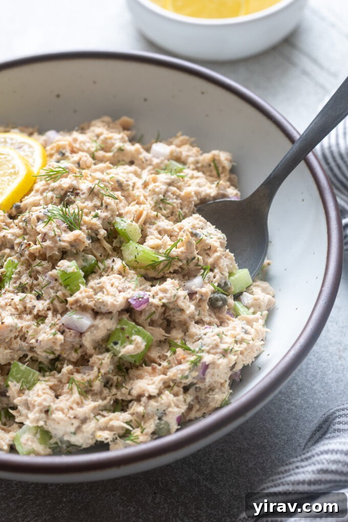 Serving spoon digging into canned wild salmon salad.