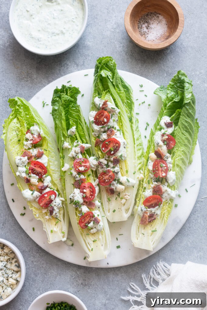 A beautifully arranged Romaine Wedge Salad with crispy bacon and blue cheese crumbles on a white platter, ready to be served.